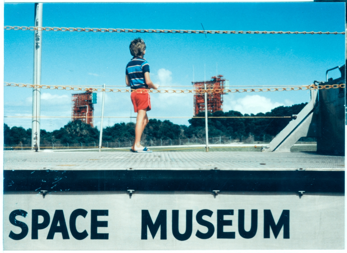 Standing on top of the LARC that was on display at the Air Force Space Museum at Cape Canaveral, Florida, Kai MacLaren considers the towers at nearby, very-much active at the time, Launch Complex 17-A (left) and 17-B (right), where Delta II rockets were launched from, which lofted both scientific and military payloads to Earth orbit, the Moon, Mars, and even a comet. Kai watched numerous Delta II launches from near his home in Cocoa Beach, Florida, and understood well just exactly what it was that he was looking at here. Kai, as does his father, enjoys high-energy achievements, and Delta II was a high-energy proposition.